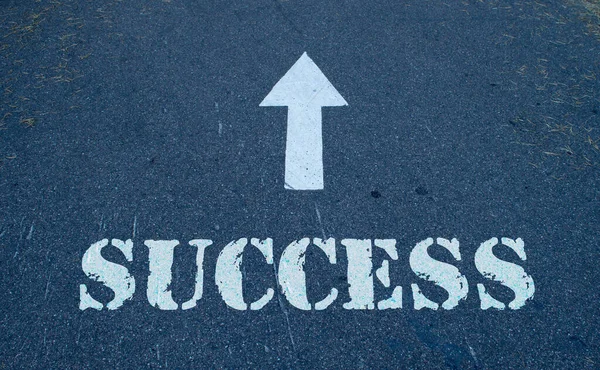 Asphalt road with arrow guideline and success letters painted on the surface — Stock Photo, Image