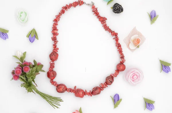 Beads and flowers on white — Stock Photo, Image