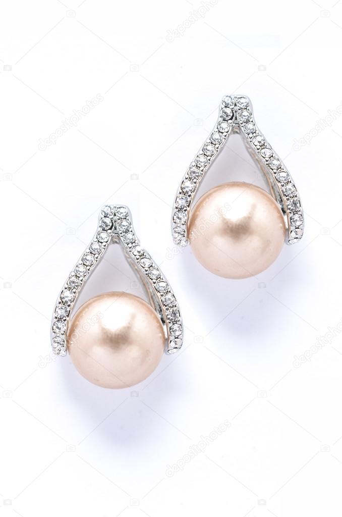 Earrings with pearls and diamonds on white background