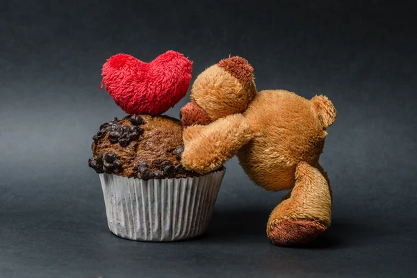 Медвежонок с шоколадными кексами и сердцем — стоковое фото