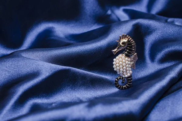 Broche de caballo de mar sobre seda —  Fotos de Stock