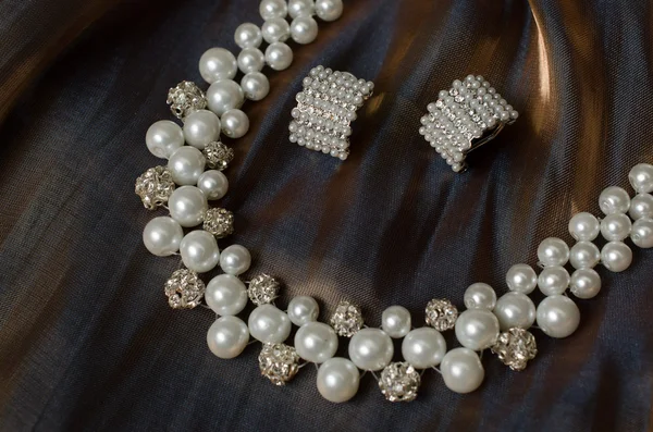 Ожерелье с серьгами на ткани — стоковое фото