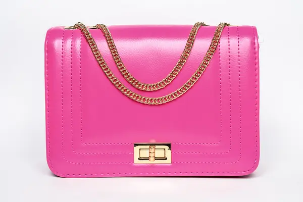 Bolso de señora rosa con cadena dorada sobre fondo blanco — Foto de Stock