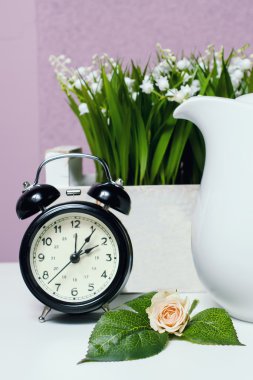 çalar saat, çaydanlık ve çiçekler ile natürmort