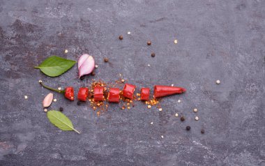 Kırmızı biber, fesleğen, sarımsaklı biber ve baharatlar siyah ahşap bir masaya konmuş mesaj yazmak için boş bir alan var.