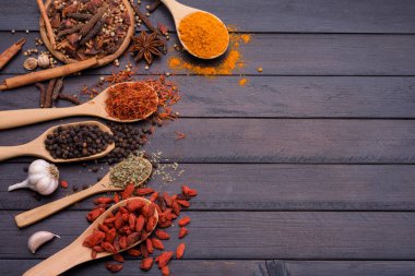 Koyu ahşap bir masada kaşık baharatlı sarımsaklı tuz biberi. Kopyalama alanı ile üst görünüm