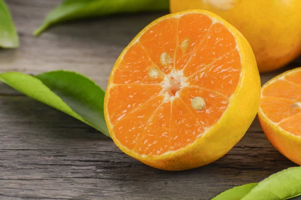 Fresh orange cut in half on a wooden table