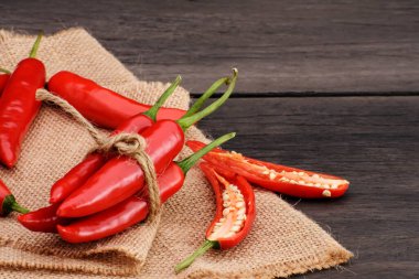 Eski bir ahşap masada taze kırmızı kırmızı biber grubu.