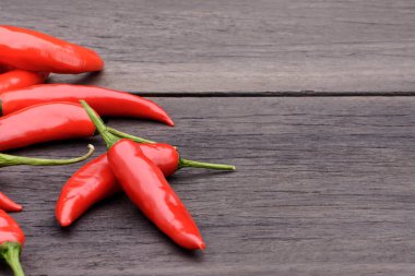 Eski bir ahşap masada taze kırmızı kırmızı biber grubu.