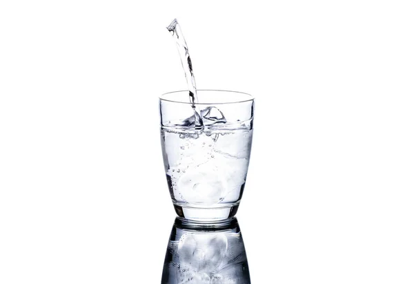 一杯加冰的水把水倒入一个白色背景隔离的杯子里 — 图库照片