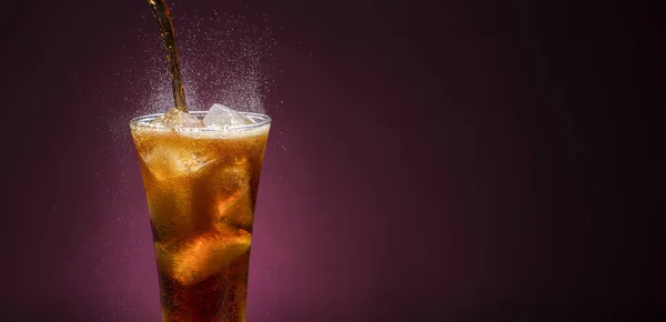 Buzlu kola bardağına köpüklü su dök. Karanlık bir arkaplanda metin kopyalamak için boşluk var.