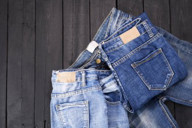 Siyah ahşap zeminde duran mavi kot pantolon. modern moda kotu