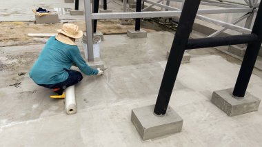 İşçiler çatılara su geçirmez, kauçuk kaplama veya lastik kaplama için güçlendirilmiş plastik ağ kuruyorlar..