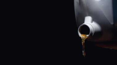 Sentetik motor yağının yavaş çekim görüntüleri, ideal performans, kayganlaştırma ve motor koruması için gerekli bir araç bakım adımı. Dijital kamerayla çekilmiş..