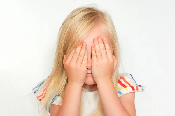 The girl is upset and covers her face with her palms Stock Picture