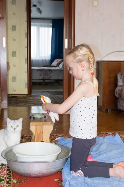 Niño lava un juguete suave con jabón en un lavabo —  Fotos de Stock