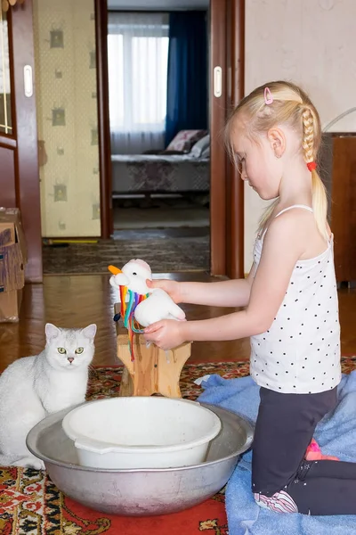 Niño lava un juguete suave con jabón en un lavabo —  Fotos de Stock