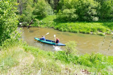  Bir kayıktaki kadın ve erkek nehirde yarışıyor.