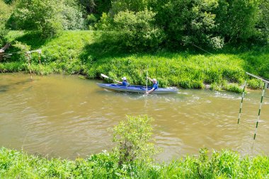  Bir kayıktaki kadın ve erkek nehirde yarışıyor.