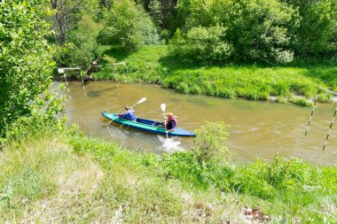  Bir kayıktaki kadın ve erkek nehirde yarışıyor.