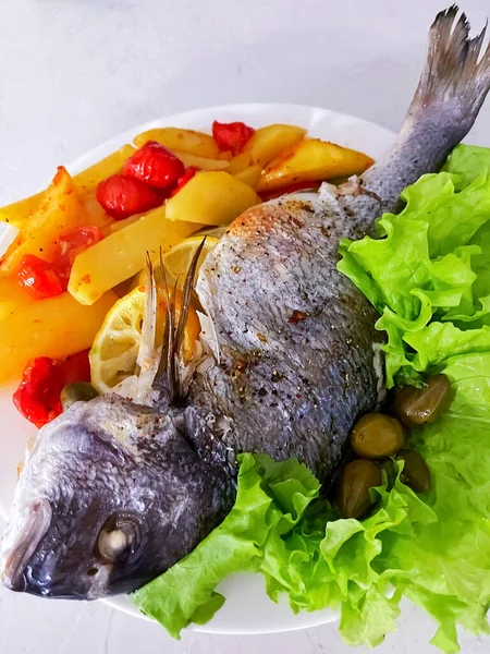 Prato de peixe dorado com batatas, tomates e alcaparras — Fotografia de Stock