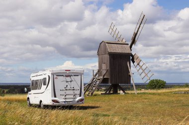 Farjestaden, İsveç - 7 Temmuz 2020 İsveç 'in Oland ilindeki eski bir yel değirmeninin yakınına park etmiş bir kampçı..
