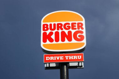 Eskilstuna, Sweden - May 17, 2021: Low angle view of the new rebranded Burger King logo on a pole outside the restaurant with drive thru isolated against a dark sky.