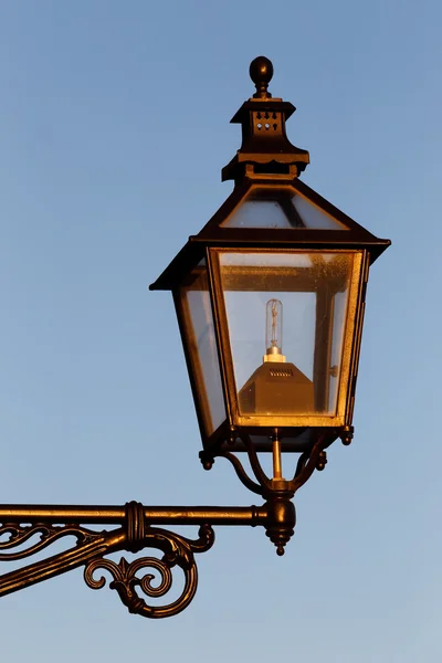 Close-up of an old style street lamp with a modern light bulb inside. — Stock Photo, Image