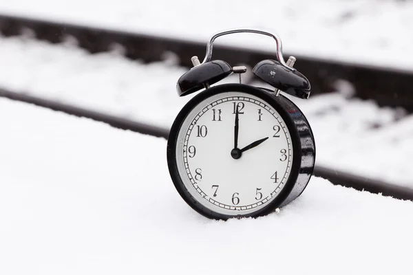 Reloj despertador sobre nieve con vías férreas —  Fotos de Stock