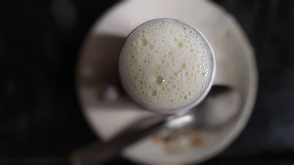 Süt dolu fincanın üstünde köpük köpükleri var.
