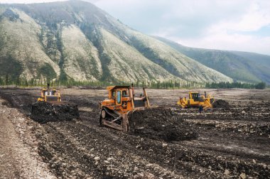 Buldozerler dağlık bir ormandaki toprağı kestiler. Madencilik