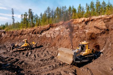 Buldozerler dağlık bir ormandaki toprağı kestiler. Madencilik