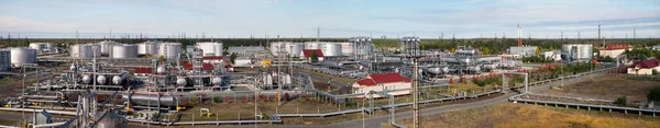 Panorama of the industrial area of the oil industry, tanks with oil products, industrial equipment, pipelines, engineering communications.   View from the fuel tank.