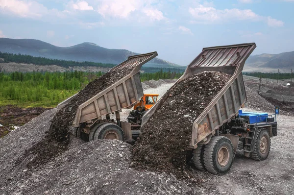 Dump trucks at work. Mining in highlands