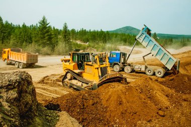  Çöp kamyonu, inşaat alanındaki sanayi bölgesinde dağ toprağını boşaltıyor.