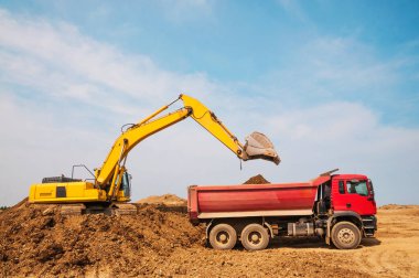 Toprak işleri, kazıcı bir kargo kamyonunun cesedine toprak yüklüyor.