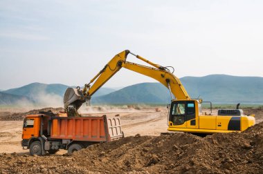 Toprak işleri, kazıcı bir kargo kamyonunun cesedine toprak yüklüyor.