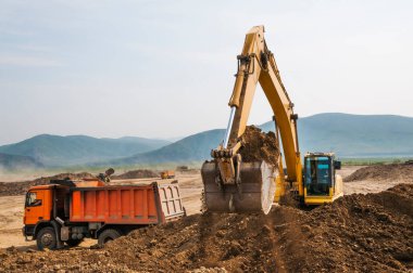 Toprak işleri, kazıcı bir kargo kamyonunun cesedine toprak yüklüyor.