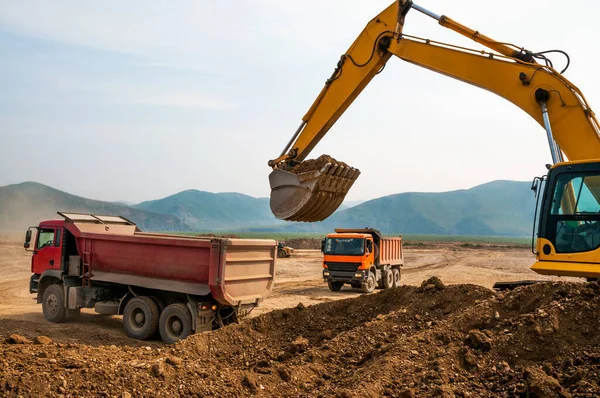 挖掘机把土装进了一辆货车的车体 — 图库照片