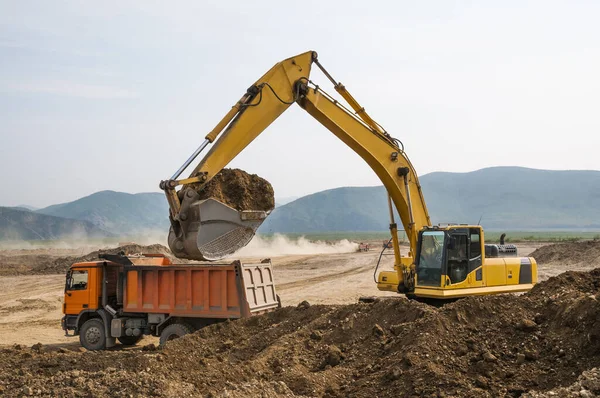 Bei Erdarbeiten Lädt Der Bagger Erde Die Karosserie Eines Muldenkippers — Stockfoto