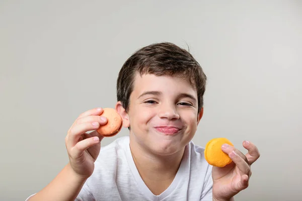 6 yaşında bir çocuk her iki elinde bir kurabiye tutuyor ve gülümsüyor..