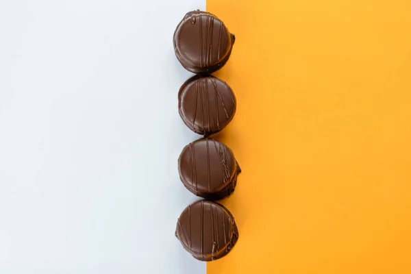 Düz bir çizgide Brezilya ballı kekleri. Turuncu ve beyaz arkaplan.