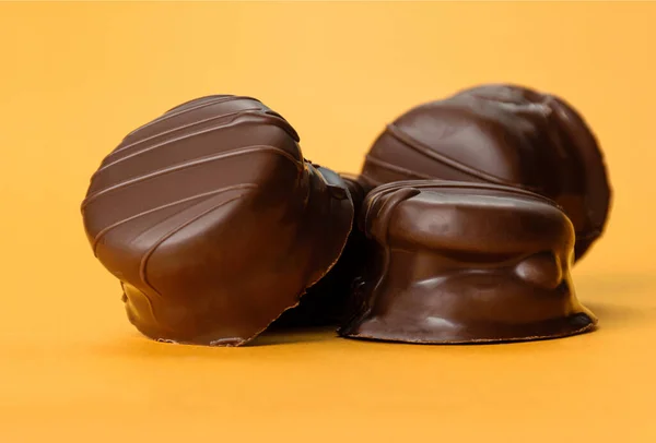 Turuncu arka planda 4 Brezilya ballı keki olan bir porsiyon.