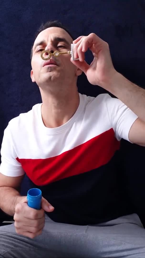 44 ans homme mature faisant de grandes bulles de savon et les tenant avec le ventilateur. — Video