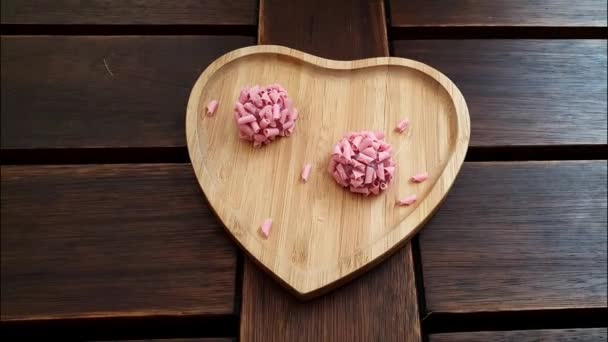 Dos brigadeiros (brigadiers) de frutas rojas en un plato de madera en un corazón shape _ smartphone video. — Vídeos de Stock