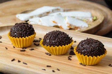 Üç tugay ahşap bir tabakta dizildi (Brezilya tatlısı). Fıstıklı turonun dibinde..