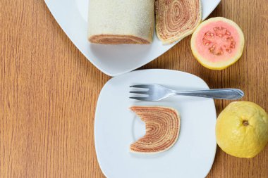 Goiabas _ top görünümünün yanında bir dilim bolo de rolo (rulo kek) dilimi.