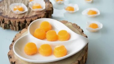 Tahta bir tahtanın üzerindeki quindins 'in bir kısmına yaklaştık. Arka planda bir el şeker alıyor..