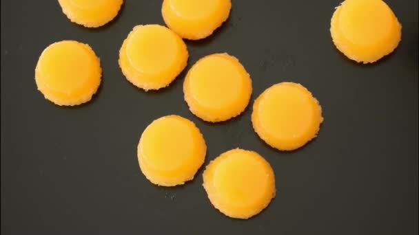 Closeup of two quindins being placed on a black background. Traditional Brazilian sweet. — Stock Video