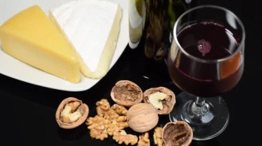 Ön planda çözünmüş kırmızı şarap, fındık, parmesan ve brie peyniri.).